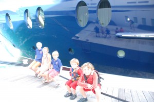 The kids sitting on the dockline of Nirvana, another megayacht.