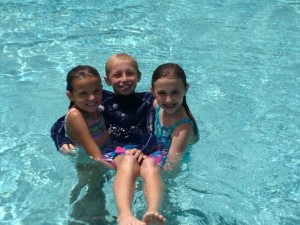 The girls carrying Bryson in the pool.